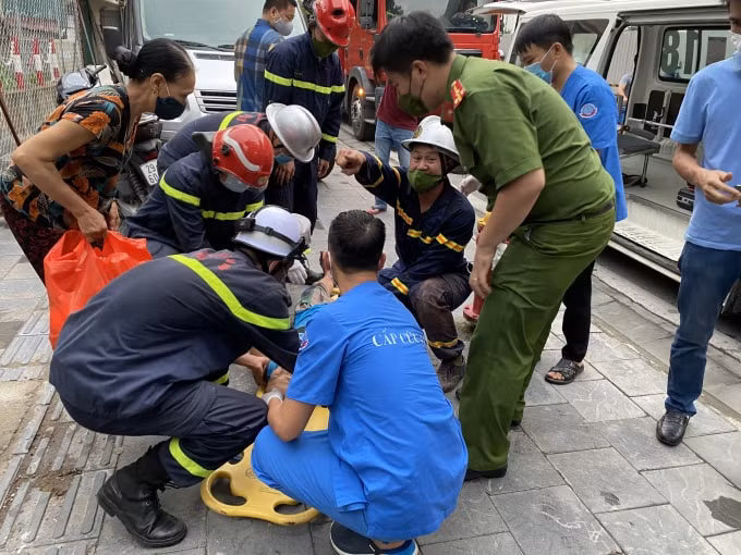 Lực lượng chức năng và người dân nhanh chóng đưa cháu đến bệnh viện sau khi đã cứu ra ngoài.