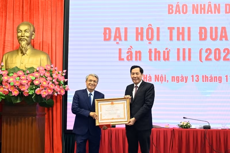 Tổng Biên tập Báo Nhân Dân Thuận Hữu thừa ủy quyền của Chủ tịch nước trao Huân chương Lao động hạng nhì cho đồng chí Hà Hồng, nguyên Trưởng Ban Bạn đọc Báo Nhân Dân. Ảnh: Duy Linh