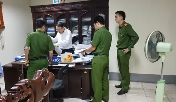 Công an tỉnh Ninh Bình tiến hành khám xét nơi làm việc của bị can Đặng Văn Quang (áo trắng). Ảnh: CAND