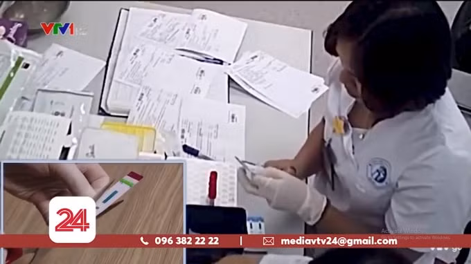 Kỹ thuật viên cắt đôi que thử xét nghiệm HIV/ Viêm gan B (Ảnh chụp màn hình)
