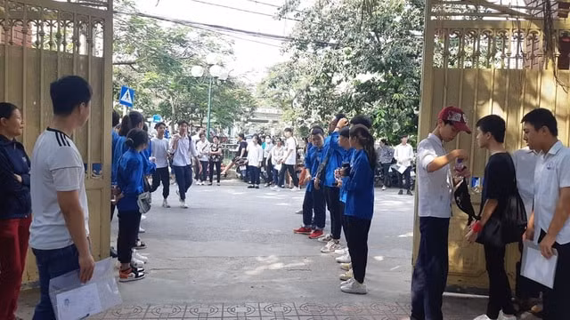 Các tình nguyện viên đón và hướng dẫn thí sinh vào khu vực làm thủ tục thi. Ảnh: TL