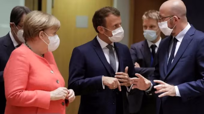 Bà Angela Merkel, ông Emmanuel Macron, và ông Charles Michel thảo luận trước khi bắt đầu hội nghị thượng đỉnh EU tại Brussels vào thứ Sáu . Ảnh: Stephanie Lecocq / Pool / Reuters