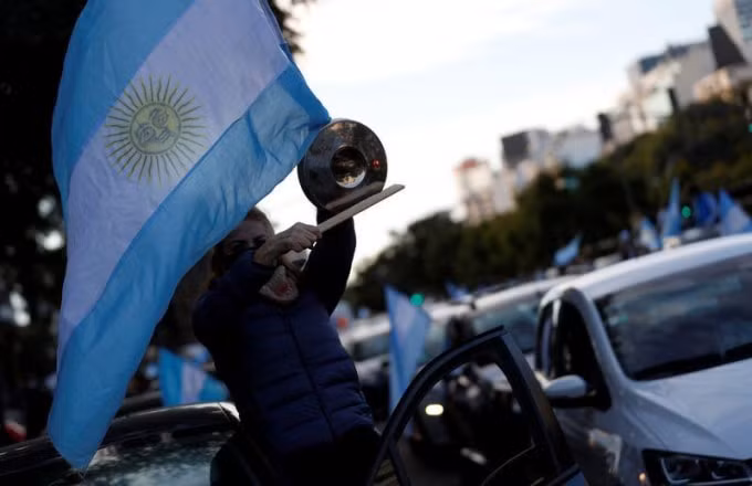 Một người dân cầm cờ biểu tình tại Buenos Aires. Ảnh: Reuters