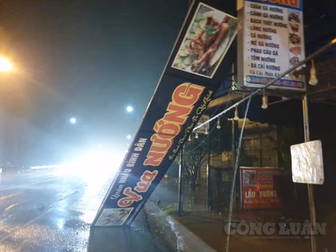 Không chỉ cây xanh mà những bảng hiệu cũng bị gió xới tung, rơi rớt xuống Quốc lộ gây cản trở giao thông.