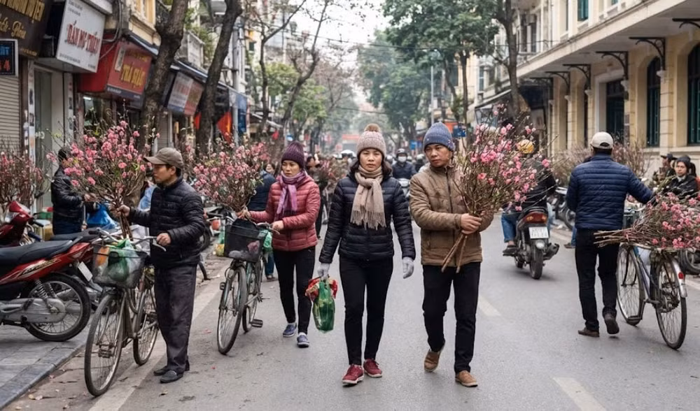 Người dân Hà Nội trong trang phục áo ấm thảnh thơi dạo phố và mua sắm cành đào Tết trong tiết trời tạnh ráo sáng Chủ Nhật 1-2 - Ảnh minh họa