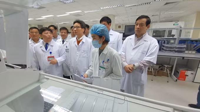 Phó Thủ tướng Vũ Đức Đam (thứ 3 từ phải) kiểm tra phương tiện xét nghiệm tại Bệnh viện Bệnh nhiệt đới Trung ương. Ảnh Bộ Y tế.