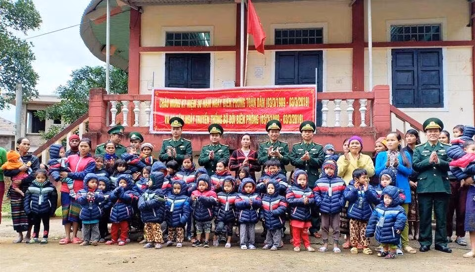 Cán bộ, chiến sĩ đồn Biên phòng Cù Bai tặng áo ấm cho các em học sinh đến trường.