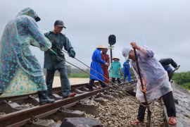 Công nhân đội mưa khắc phục tuyến đường sắt Bắc - Nam