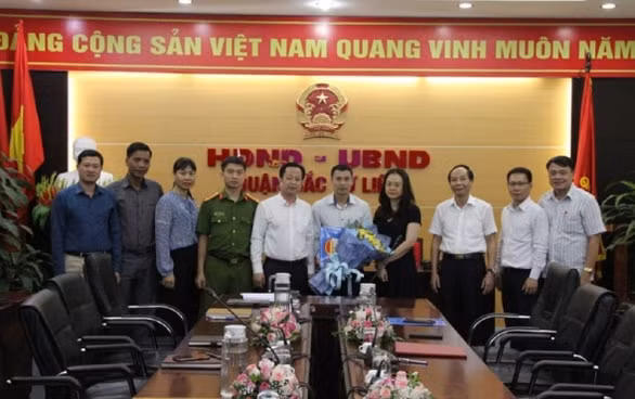 Lãnh đạo Quận Bắc Từ Liêm trao quyết định và tặng hoa chúc mừng ông Đỗ Chí Linh - Ảnh: Cổng TTĐT quận Bắc Từ Liêm