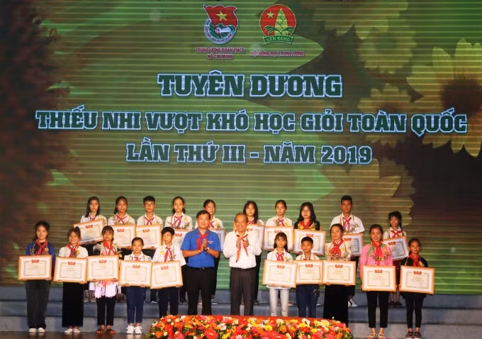 Phó Thủ tướng Thường trực Trương Hòa Bình cùng Bí thư thứ nhất Trung ương Đoàn Lê Quốc Phong trao hoa, bằng khen cho các em học sinh vượt khó học giỏi tiêu biểu toàn quốc. Ảnh: VGP