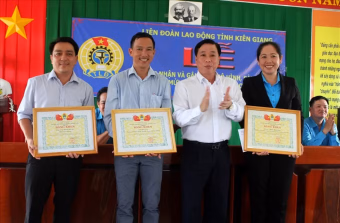 Chủ tịch LĐLĐ Kiên Giang Trần Thanh Việt gắn biển cho công trình Góc thư viện lớp học cho Trường PTTH Long Thạnh (huyện Giồng Riềng). Ảnh: Lục Tùng