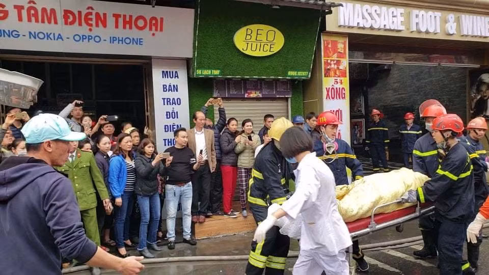 Nữ nhân viên tử vong được đưa ra khỏi hiện trường. Ảnh: TL