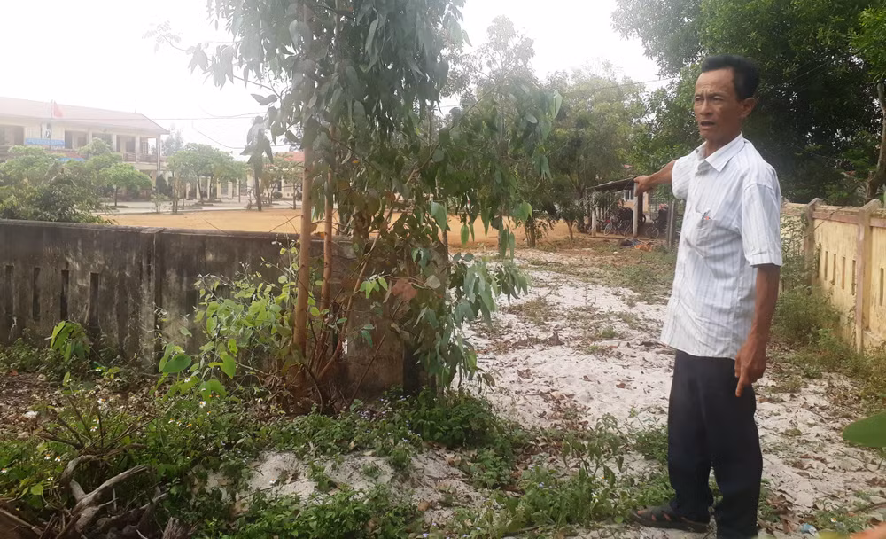 Ông Nguyễn Văn Bắc cha đẻ của cháu bé xấu số, chỉ lối đi thông thương giữa Trường cấp 1 và Trường Mầm non Vĩnh Thái (Ảnh: Cái Văn Long).