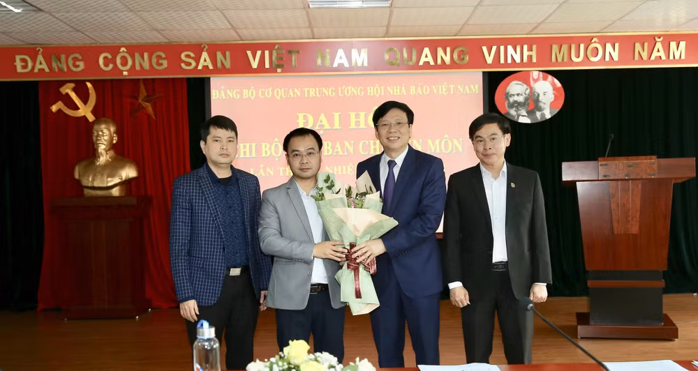 Đồng chí Hồ Quang Lợi, Phó Bí thư Đảng Đoàn Hội Nhà báo Việt Nam, Bí thư Đảng Ủy Cơ quan trung ương Hội Nhà báo Việt Nam tặng hoa chúc mừng Chi ủy nhiệm kỳ mới. Ảnh: Sơn Hải
