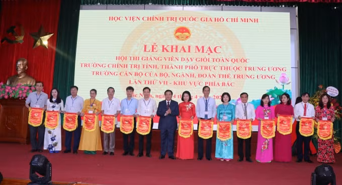Đồng chí Nguyễn Xuân Thắng, Ủy viên Bộ Chính trị, Giám đốc Học viện Chính trị Quốc gia Hồ chí Minh trao cờ lưu niệm cho các đoàn thi