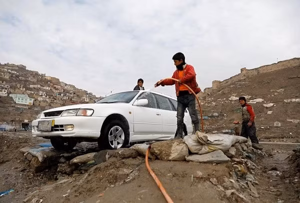 Các bé trai rửa xe kiếm sống tại tỉnh Kabul, Afghanistan. Ảnh: Reuters