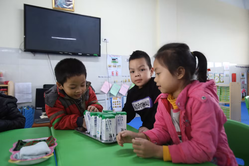 Các cô giáo đang chuẩn bị sữa cho các bé tham gia chương trình Sữa học đường uống tại một điểm trường ở Hà Nội