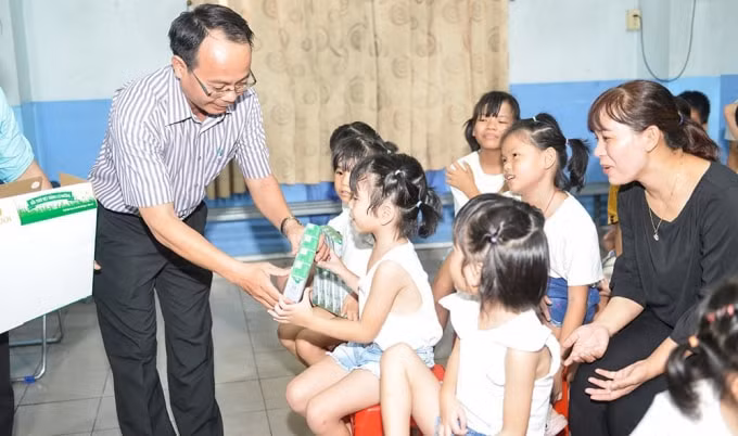 Các em nhỏ Làng Thiếu niên Thủ Đức hân hoan nhận sữa từ các đại biểu trong chương trình Quỹ sữa Vươn cao Việt Nam