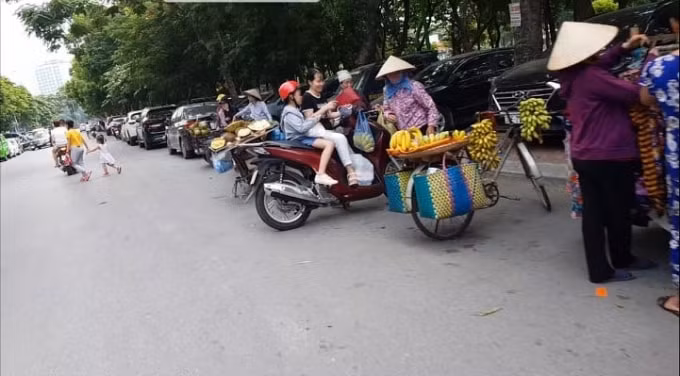 Bãi xe, người bán hàng rong lấn chiếm lòng lề đường đối diện chung cư 2B Linh Đàm.