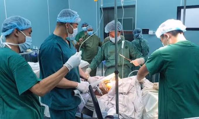 Các bác sĩ phẫu thuật lấy thanh sắt ra khỏi bụng bệnh nhân. Ảnh: TL.
