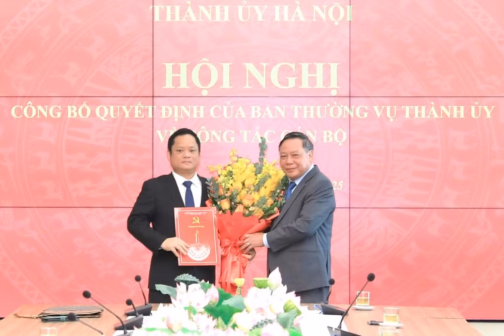 Phó Bí thư Thường trực Thành ủy Hà Nội Nguyễn Văn Phong trao quyết định và tặng hoa chúc mừng tân Phó Trưởng ban Tuyên giáo và Dân vận Thành uỷ Vũ Minh Tuấn