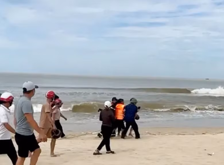 Người dân đưa thi thể nạn nhân lên bờ.