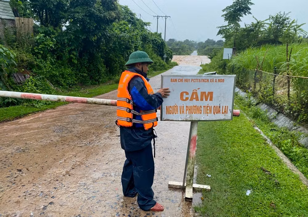 Lực lượng tiến hành lập chốt chặn tạm thời cấm người và phương tiện lưu thông qua những ngầm tràn đang bị ngập (Ảnh: BP).