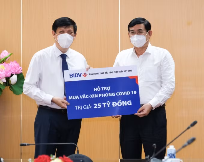 Chủ tịch Hội đồng quản trị Ngân hàng BIDV trao biểnbiển hỗ trợ mua vắc xin phòng COVID -19 số tiền 25 tỷ đồng.