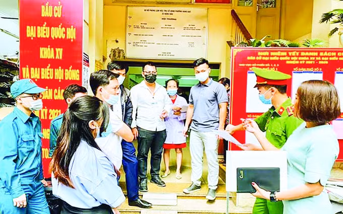 Kiểm tra công tác phòng, chống dịch Covid-19 tại nơi niêm yết danh sách cử tri phường Hàng Bạc (quận Hoàn Kiếm). Ảnh: Đặng Giang