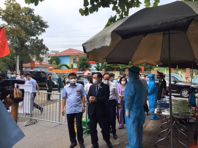 Chủ tịch Quốc hội Vương Đình Huệ sát khuẩn trước khi vào kiểm tra khu vực bỏ phiếu của công nhân.