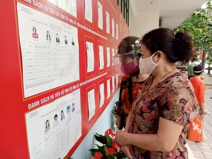 Từ sáng sớm, người dân đã có mặt tại điểm bỏ phiếu để xem danh sách và tiểu sử của người ứng cử