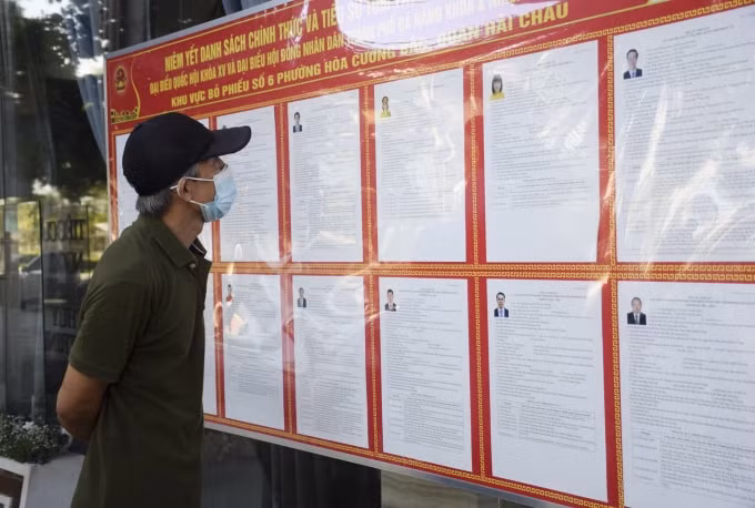 Người dân tìm hiểu tiểu sử tóm tắt và chương trình hành động của các ứng cử viên. ẢNH: DUY ANH