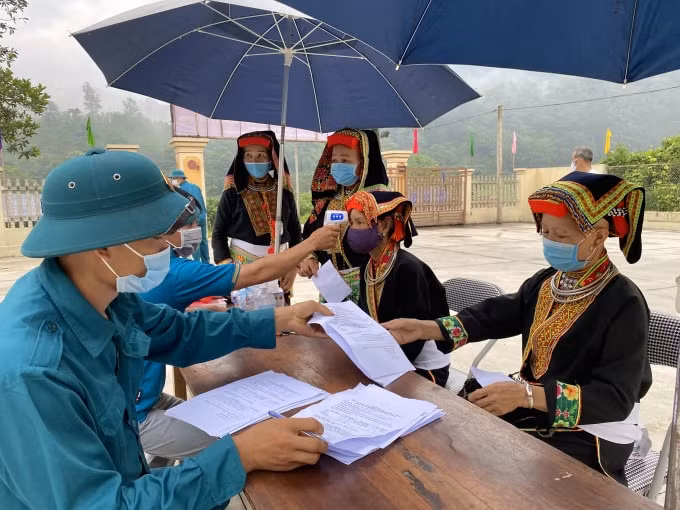 Các cử tri người dân tộc Dao ở xóm Ba Nhất, xã Phú Thượng, huyện Võ Nhai làm thủ tục kê khai y tế trước khi vào bầu cử. Ảnh: Báo Thái Nguyên