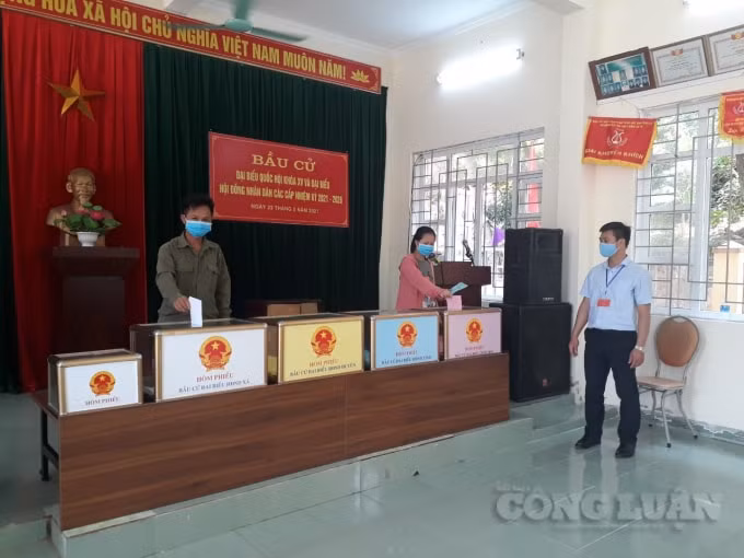 Cử tri đi bỏ phiếu được cán bộ Tổ bầu cử huwowgs dẫn thực hiện dãn cách theo yêu cầu 5K. Ảnh: Nguyễn Quân.