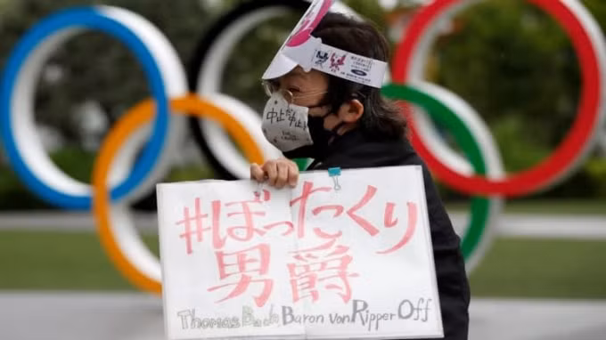 Một người biểu tình giơ tấm biển phản đối Thế vận hội Tokyo - Ảnh: Reuters