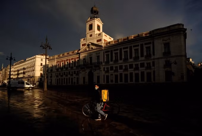 Một nhân viên giao hàng giữa tâm dịch tại Madrid, Tây Ban Nha. Ảnh:Reuters
