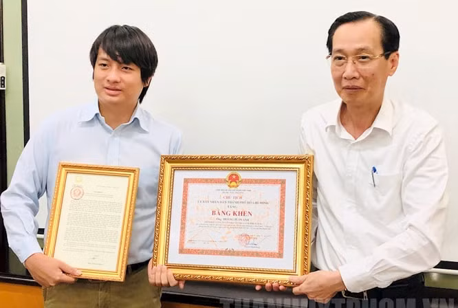 Thừa ủy quyền Phó Chủ tịch nước, Phó Chủ tịch Thường trực UBND thành phố Hồ Chí Minh Lê Thanh Liêm (bên phải) trao Thư khen cho anh Hoàng Tuấn Anh. Ảnh: HNM