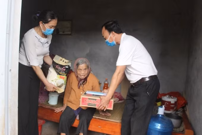 Ông Chu Văn Thích, Trưởng thôn Vật Phụ đến tận căn nhà của bà Dương Thị Thi, hộ nghèo neo đơn, 80 tuổi để trao quà hỗ trợ Covid-19.