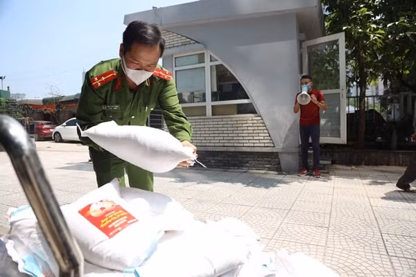 Công an phường Yên Hòa đã cử Thượng úy Đào Xuân Hưng có mặt từ sớm để hỗ trợ Báo Nông thôn Ngày nay/Điện tử Dân Việt ổn định an ninh trật tự khu vực cấp phát gạo.