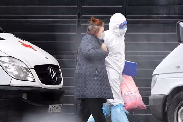 Một bác sĩ đang đưa bệnh nhân đi xét nghiệm Covid-19 ở Moscow, Nga. Ảnh: Sputnik