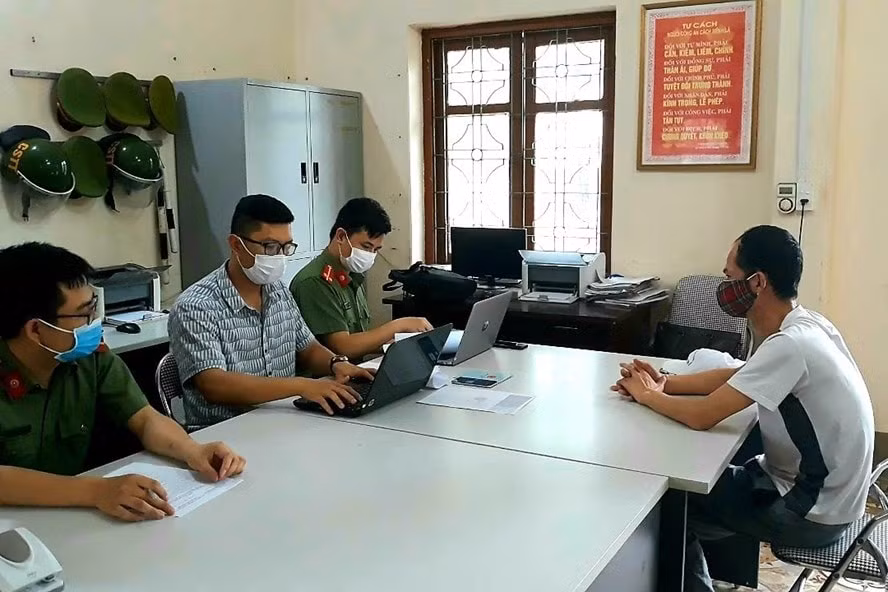 Lực lượng công an Quảng Ninh làm việc với đối tượng bình luận sai sự thật trên Facebook. Ảnh: PV