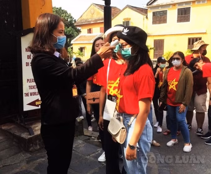 Đo thân nhiệt cho du khách tham quan phố cổ.