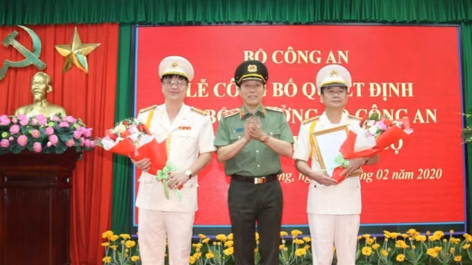 Trung tướng Lương Tam Quang trao Quyết định và tặng hoa chúc mừng Đại tá Nguyễn Minh Ngọc (phải) và Đại tá Lê Minh Quang.