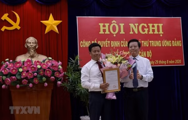 Ông Mai Văn Chính, Ủy viên Trung ương Đảng, Phó trưởng Ban Tổ chức Trung ương trao Quyết định của ban Bí thư cho ông Lê Quân. Ảnh: TTXVN