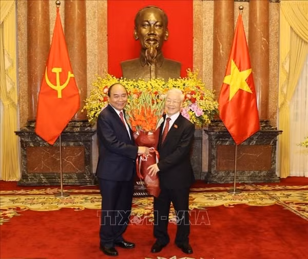 Chủ tịch nước Nguyễn Xuân Phúc tặng hoa Tổng Bí thư Nguyễn Phú Trọng, nguyên Chủ tịch nước. Ảnh: TTXVN