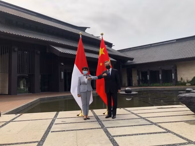 Bộ trưởng Ngoại giao Indonesia Marsudi (trái) và Ngoại trưởng Trung Quốc Vương Nghị chạm khuỷu tay - Ảnh: Twitter