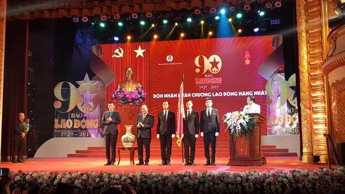 Thủ tướng Nguyễn Xuân Phúc tặng món quà có ý nghĩa cho tập thể Báo Lao Động, đó là chiếc bình gốm in hình tòa nhà Báo Lao Động. Ảnh: Huy Hoàng