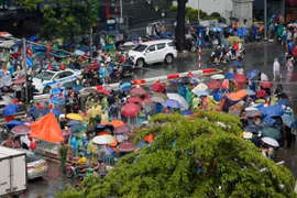 Người dân đội mưa ngồi chờ xem diễu binh