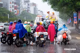 Cảnh sát giao thông hỗ trợ người dân di chuyển qua vùng ngập