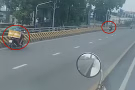 Nhiều xe máy nối đuôi nhau chạy ngược chiều trên cầu vượt ở Bình Dương